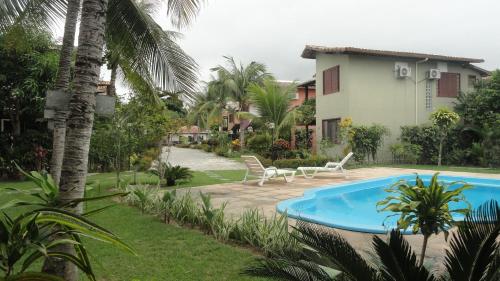 un complexe avec une piscine et une maison dans l'établissement Casa Praia de Taperapuan, Porto Seguro, à Porto Seguro
