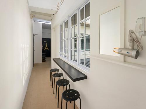 a hallway with stools and a row of windows at 7 Wonders Hostel at Upper Dickson in Singapore
