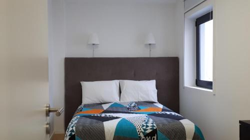 a bedroom with a bed with a colorful quilt on it at TMB (Train / Metro& Bus ) Oporto Station House in Porto