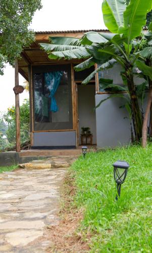 a house with two lights in the grass at Karungi Camp in Rubuguli