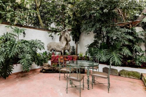 a table and chairs with a statue of a horse at Los Camilos in Mexico City