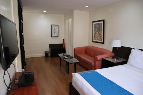 a hotel room with a bed and a couch at Domicilio Lorenzo in Davao City