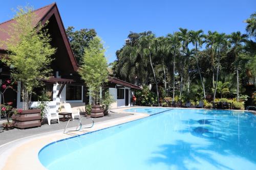 a swimming pool at a resort with palm trees at Domicilio Lorenzo in Davao City