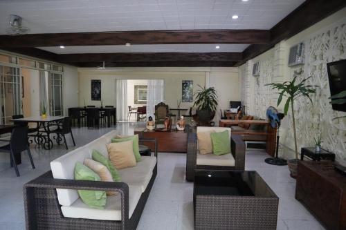 a living room with a couch and chairs and a tv at Domicilio Lorenzo in Davao City