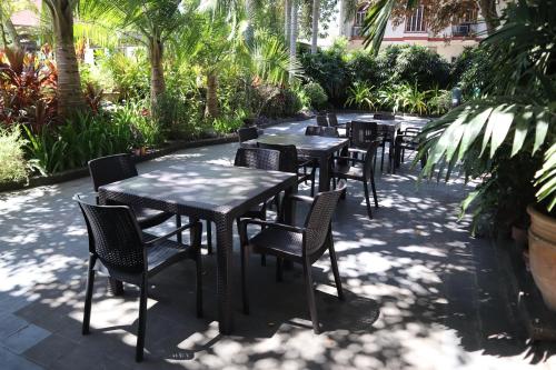 a row of tables and chairs with trees and plants at Domicilio Lorenzo in Davao City
