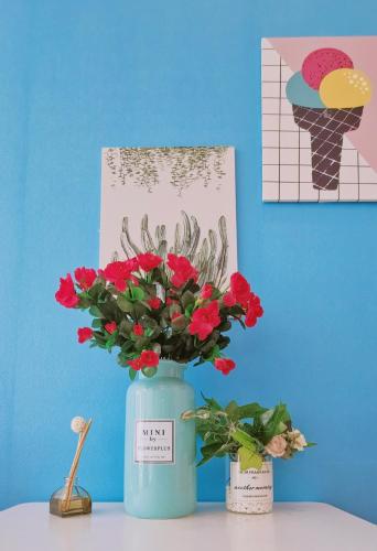 a blue vase with red flowers on a table at Lavender Apartment in Guangzhou