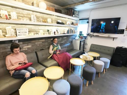two women sitting on a couch in a coffee shop at The Cube Hotel in Seoul