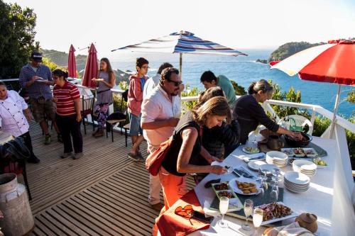 a group of people standing around a table with food at Hostería La Casa del Mar in Bahía Mansa
