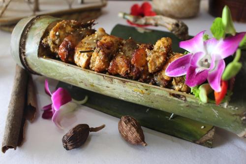a plate of food with nuts and flowers on a table at Muong Thanh Grand Hoang Mai - Nghe An in Hoang Mai