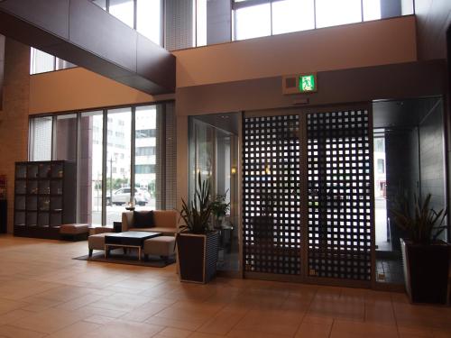 an office lobby with a exit sign on the door at K's Street Hotel Miyazaki in Miyazaki
