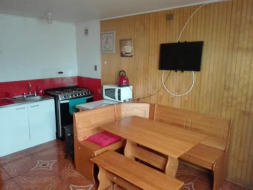 cocina pequeña con mesa de madera y fogones en Tres de junio, en Puerto Montt