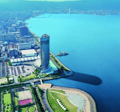 an aerial view of a city with a tower next to the water at Lake Biwa Otsu Prince Hotel in Otsu
