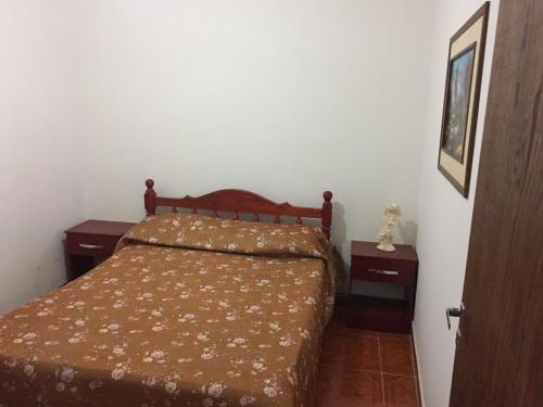 Un dormitorio con una cama y dos mesitas de noche. en Departamento Ciro, en San Salvador de Jujuy