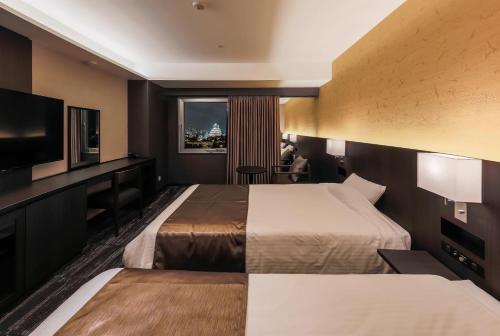 a hotel room with two beds and a flat screen tv at KKR Hotel Osaka in Osaka