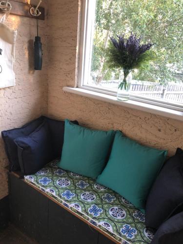 a couch with pillows sitting under a window at Olive's Cottage in Mount Gambier