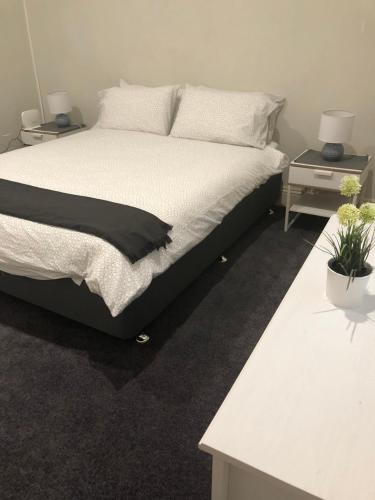 une chambre avec un lit et deux tables de nuit dans l'établissement Olive's Cottage, à Mount Gambier