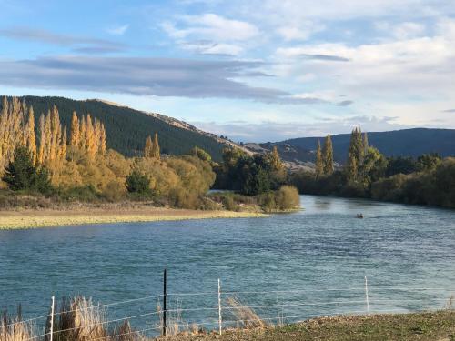 a view of a river with trees in the background at Mata-au Lodge in Beaumont