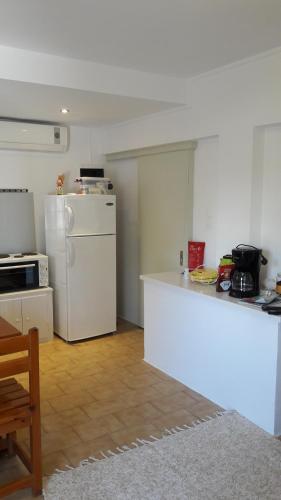 a kitchen with a white counter and a refrigerator at Ava Apartments in Agios Gordios