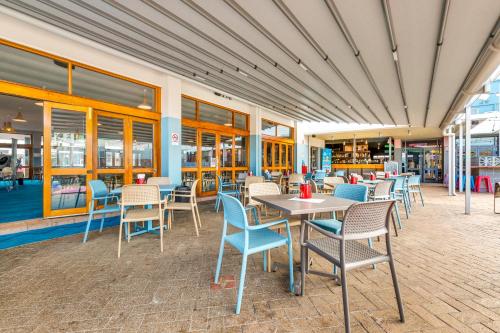 a patio with tables and chairs in a restaurant at Nightcap at Ocean Beach Hotel in Umina