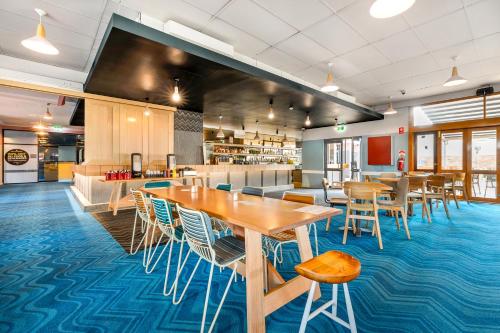 a restaurant with tables and chairs and a cafeteria at Nightcap at Ocean Beach Hotel in Umina