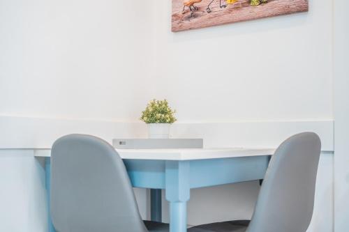 a blue table with chairs and a plant on it at Valletta Collection - GB Suites in Valletta