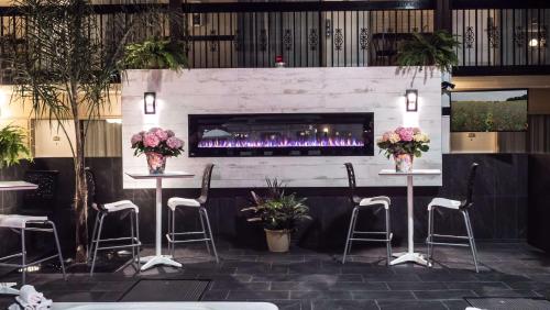 a bar with a fireplace in a room with stools at Best Western Plus Cairn Croft Hotel in Niagara Falls