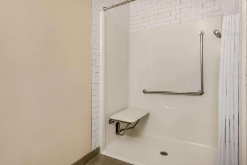 a white bathroom with a shower with a toilet at Canalta Airdrie in Airdrie