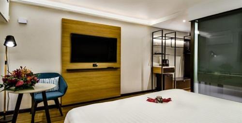 a hotel room with a bed and a table and a tv at Tanoa Plaza Hotel in Suva