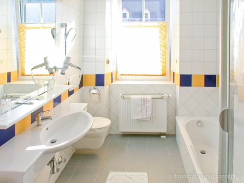 a bathroom with a sink and a toilet and a tub at Gasthof Hensle in Sankt Gallen