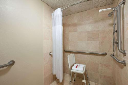 a bathroom with a shower with a shower curtain at Baymont by Wyndham Mandan Bismarck Area in Mandan