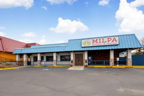 a mizzza restaurant and convenience store with a parking lot at Economy Inn & Suites in Denton