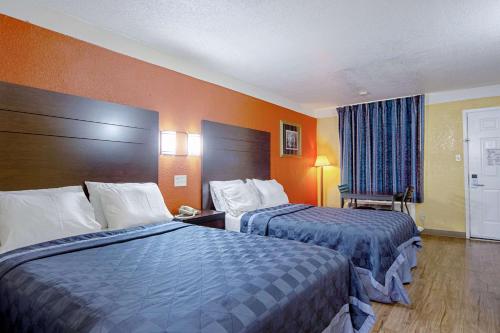 a hotel room with two beds and a window at Economy Inn & Suites in Denton