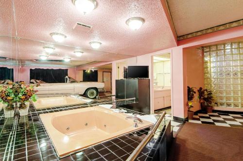 a large bathroom with a tub and a car in it at Economy Inn & Suites in Denton