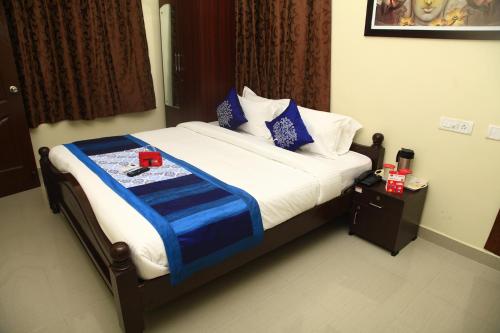 Una cama con una manta azul y blanca. en Jai Palace en Chennai