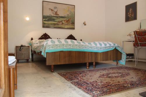 een slaapkamer met een bed en een tapijt bij Shahar Palace in Jaipur