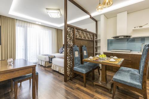 a room with a dining table and a bedroom at Balcona Hotel Da Nang in Da Nang
