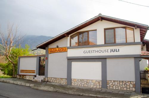 a building with two white garage doors on it at Guesthouse Juli in Sapareva Banya