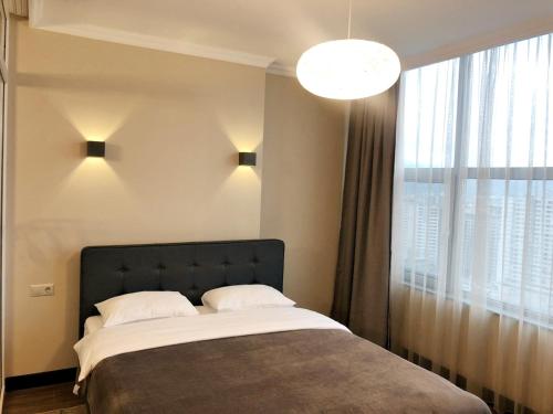 a bedroom with a bed and a large window at Pirosmani Mini Hotel in Batumi