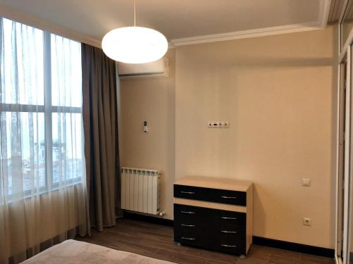 a room with a dresser and a large window at Pirosmani Mini Hotel in Batumi