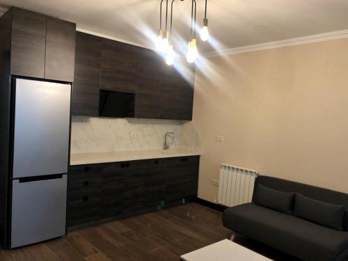 a living room with a couch and a kitchen at Pirosmani Mini Hotel in Batumi