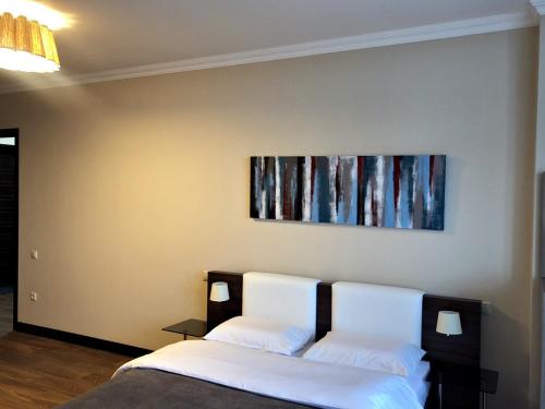 a bedroom with two beds and a painting on the wall at Pirosmani Mini Hotel in Batumi