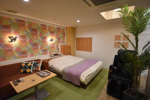 a hotel room with a bed and a table at Hotel Melia RESORT(Adult Only) in Fuefuki