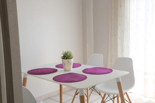 a white table with purple cushions on it at Hotel Strass in Paralia Katerinis