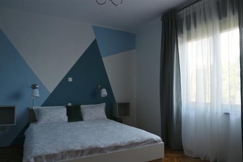 a blue bedroom with a bed and a window at Apartment Ivana in Novi Vinodolski