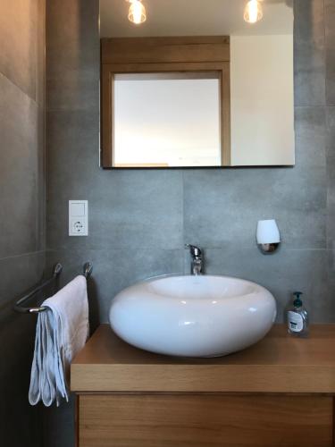 uma casa de banho com um lavatório branco e um espelho. em Kallido em Hermeskeil