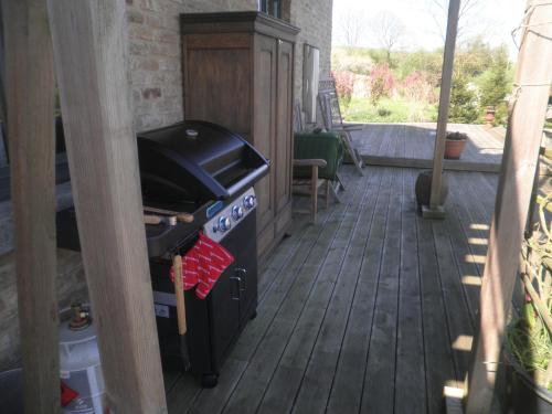 a outdoor kitchen with a stove and a television at Un brin de Paradis "appartement de 100 m²" in Harzé