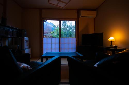a living room with a table in front of a window at Oyado Den Rikyu in Yufuin