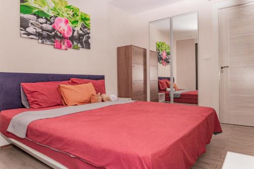 um quarto com uma cama grande e um cobertor vermelho em Baan Suan Lalana em Praia de Jomtien
