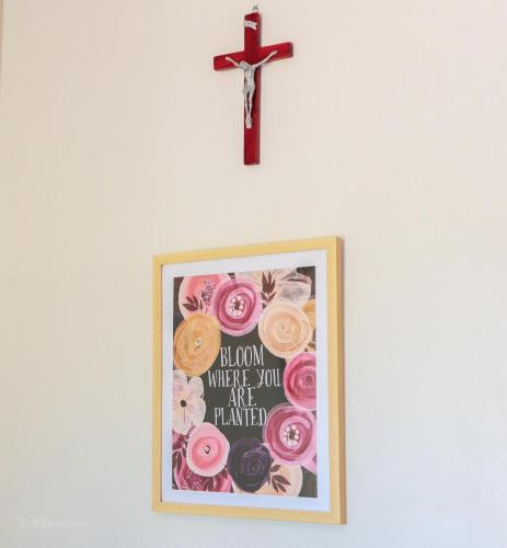 a cross hanging on a wall with a picture at RQS Hostel in Tacloban