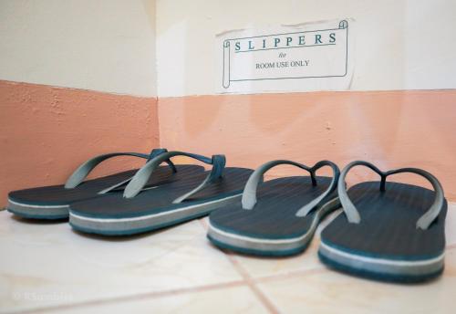 a group of sandals are lined up against a wall at RQS Hostel in Tacloban